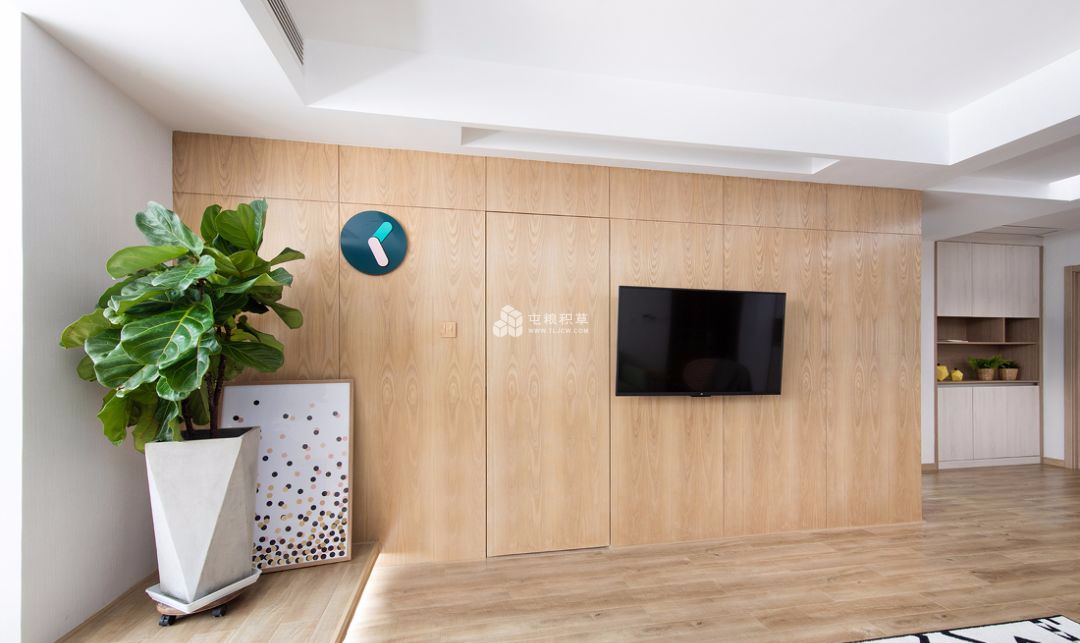 电视背景墙采用隐形门的设计,温润的原木色加上大面积的白色,给予客厅
